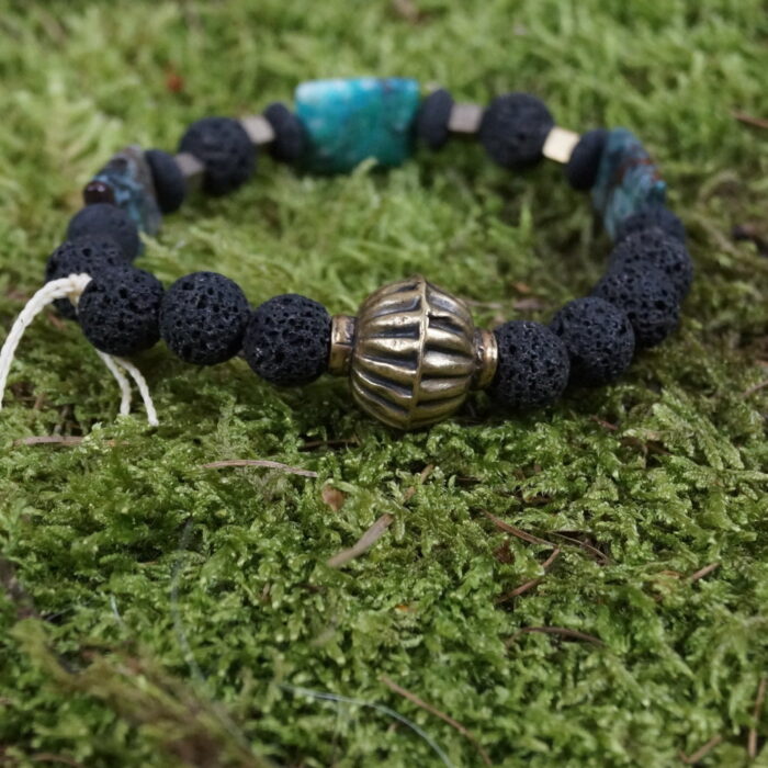 "Elemental Prosperity" ist mehr als ein Armband – es ist ein harmonischer Tanz der Elemente. Die Erdkraft der Lava, die heilende Natur des Chrysokolls und die Stärke des Hämatits vereinen sich mit einer antiken Geldperle aus Afghanistan, die Wohlstand symbolisiert. Trage dieses einzigartige Accessoire, um Elemente und Energie in einem Schmuckstück zu erleben