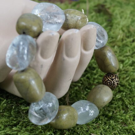 "Savana-Magie" - Ein Abenteuer in Form eines Armbands mit warmen Afrikaopalen und erfrischendem Bergkristall. Die 11mm große Bronceperle mit Wikingerspiralen verbindet Vergangenheit und Gegenwart in einem kraftvollen Trio, das spirituelle Reisen und Lebensfreude fördert. Vorteilhaft für das Herz-Chakra, symbolisiert die Bronceperle mit ihrer warmen Patina Stärke und Beständigkeit, während regelmäßige Reinigung die lebendige Energie bewahrt.