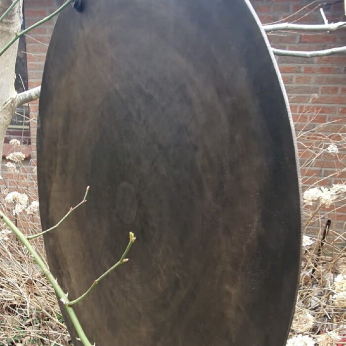 zeitloser Klänge mit unserem exquisiten Bronce-Gong, einem Meisterwerk aus Schönheit und Klang. Dieses majestätische Instrument, reich verziert mit faszinierenden Mantras in Sanskrit, verführt die Sinne und entfacht eine Atmosphäre der spirituellen Ruhe.